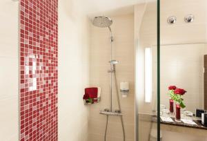 a bathroom with a shower with a glass door at ZELLER's Quartier Hotel in Königsbrunn