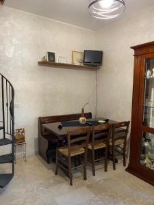 a dining room table with chairs and a tv on the wall at APT Via Calabria 6da Francesca in Marina di Monasterace +13 photos