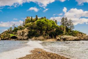 a small island in the water near a beach at SuiteLina in Giardini Naxos