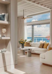 a living room with a couch and a large window at One&Only Aesthesis, Athens in Athens