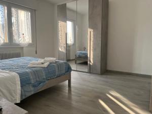 メストレにあるAt Home Mestre Via Nigra Venezia come a casa ma in vacanzaのベッドと大きな鏡のある寝室