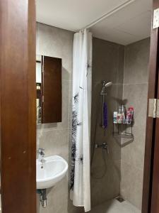 a bathroom with a sink and a shower curtain at Meisterstad Pollux Habibie Apartment Batam Studio805 in Batam Center