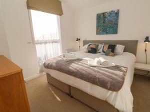 een slaapkamer met een groot bed met twee handdoeken erop bij Una, Lodge 70 in St Ives +40 foto's