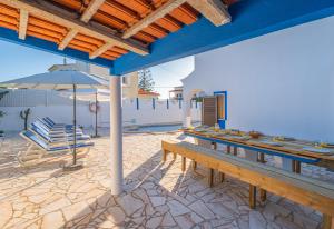 a patio with a table and chairs and an umbrella at Villa Amaris by Atlantic Places in Albufeira