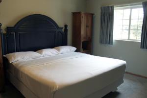 a bedroom with a large bed with white sheets and a window at 2 Bedroom accessible condo in Eagle River