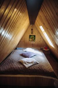 a bedroom with a bed in a wooden room at Aframe LINIȘTEA PĂDURII NĂMĂEȘTI in Nămăeşti +61 photos