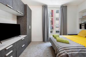 a bedroom with two beds and a flat screen tv at Porta Venezia Comfortable Apartment in Milan