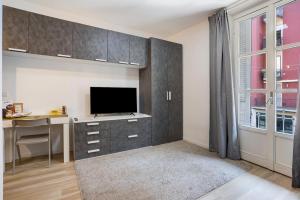 a living room with a desk with a tv and a window at Porta Venezia Comfortable Apartment in Milan