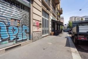 a street with graffiti on the side of a building at Porta Venezia Comfortable Apartment in Milan