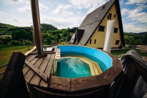 a swimming pool on a deck next to a house at Aframe LINIȘTEA PĂDURII NĂMĂEȘTI in Nămăeşti