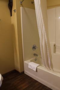 a bathroom with a tub and a shower with a towel at 2 Bedroom Condo at Wild Eagle Lodge in Eagle River