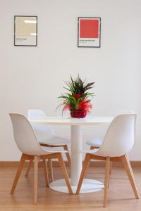a white table with two chairs and a potted plant at Studio Piramide in Rome