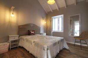 a bedroom with a bed and a chair and a window at Casa Marinda T3 com Piscina in Vila Nova de Milfontes