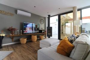 a living room with a couch and a flat screen tv at Casa Marinda T3 com Piscina in Vila Nova de Milfontes