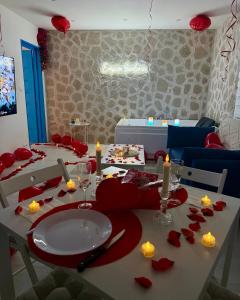 - une table à manger avec des pétales de rose rouge dans l'établissement Évasion Santorin - Jacuzzi & Relax, au Havre 11 autres photos