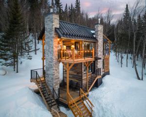 a log cabin in the snow in the woods at CHAMONIX - Micro Chalet with Panoramic Mountain Views near Québec in Lac-Beauport
