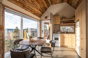 a kitchen and dining room with a table and chairs at CHAMONIX - Micro Chalet with Panoramic Mountain Views near Québec in Lac-Beauport