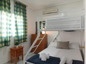 a bedroom with a bunk bed with a ladder at Bungalow near the beach in Torrevieja, Aguas Nuevas in Torrevieja +38 photos