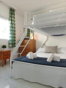 a bedroom with a bunk bed with two towels at Bungalow near the beach in Torrevieja, Aguas Nuevas in Torrevieja
