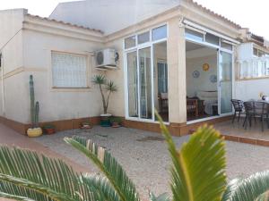 a house with a patio and a dining room at Bungalow near the beach in Torrevieja, Aguas Nuevas in Torrevieja