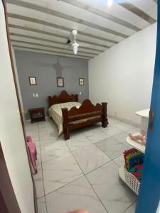 Casa Temporada Maria Antônia في باراتي: غرفة نوم بسرير وأرضية من البلاط