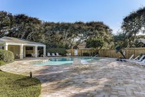 a swimming pool in a yard with chairs and a fence at 5032 Outrigger in Fernandina Beach