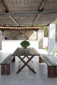 a wooden picnic table with a potted plant on it at Argo-studios in Kini