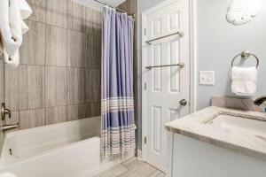a bathroom with a tub and a shower curtain at 96097 Piney Island in Fernandina Beach +23 photos