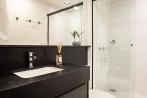 a bathroom with a sink and a shower at Loft 613 Canto com garagem in Pelotas +19 photos