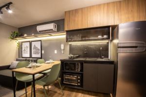 a small kitchen with a table and a refrigerator at Loft 613 Canto com garagem in Pelotas