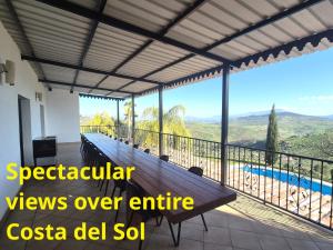 a balcony with a wooden bench and a view at Complete Private Mansion & private pool with spectacular views over entire Costa del Sol 'SAN JACINTO' in Tolox