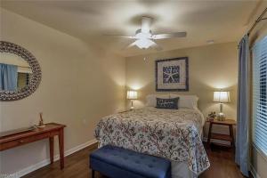 a bedroom with a bed and a ceiling fan at Condo Near the Beach in Fort Myers +14 photos