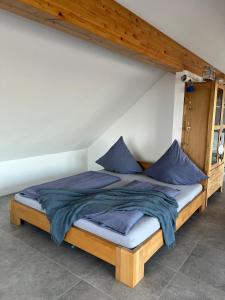 a bed with blue pillows on it in a room at Haus Villa-Moderne Galeriewohnung in Wallersdorf-Haidlfing in Wallersdorf