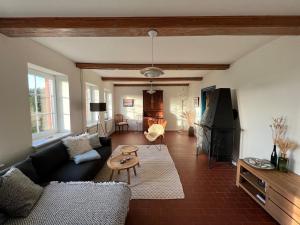 a living room with a couch and a table at Deichkieker - charmantes Ferienhaus mit großem Garten in Alleinlage nahe der Nordsee in Ockholm