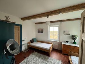 a bedroom with a bed and a window at Deichkieker - charmantes Ferienhaus mit großem Garten in Alleinlage nahe der Nordsee in Ockholm