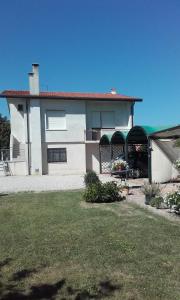 a white house with a porch and a yard at Il Giardino dei Ciliegi in Passarella