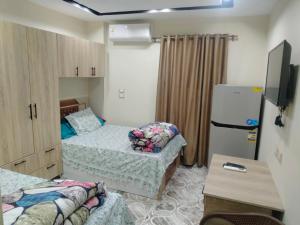 10月6日市にあるEL Hosary Houseのベッド2台、冷蔵庫が備わる小さな客室です。