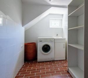 a washer and dryer in a white laundry room at Vila Mar Beach House in Arcozelo