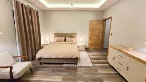 a bedroom with a bed and a couch and a chair at Modern Retreat - Comfort & Style in Hermitage