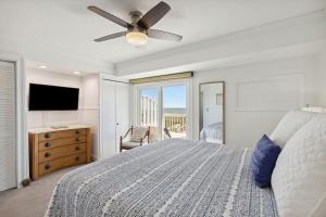 una camera da letto con un letto e un ventilatore a soffitto di 95100 Sandpiper a Fernandina Beach Altre 32 foto