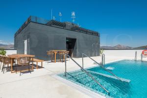 a house on the water with a table and a swimming pool at Panoramic skyrise on the 20th floor by REMS in Málaga