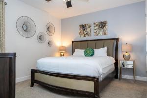 a bedroom with a large bed with white sheets at 510 BS - 5BD Cozy Family Haven with Pool in Orlando +114 photos