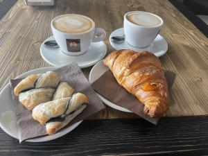 a table with two plates of pastries and two cups of coffee at B&B Sa Clarera in Baunei