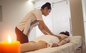 a woman laying on a bed while a woman is getting a massage at Gran Hotel de Lago - Shushufindi in Shushufindi