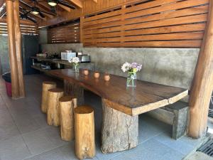 a wooden table with vases of flowers on top at Casa Aura Beachfront B&B in Tamarindo