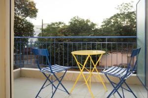 two blue chairs and a yellow table on a balcony at Space AB central in Kalamata