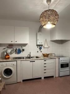 a kitchen with a sink and a washing machine at Casa do Ocaso in Luz +26 photos