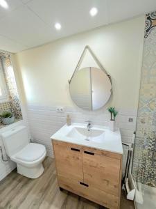 ein Badezimmer mit Toilette, Waschbecken und Spiegel in der Unterkunft Valentina Home in Córdoba