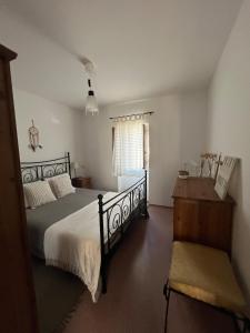 a bedroom with a bed and a desk and a window at Casa do Ocaso in Luz