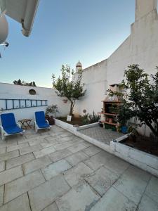 two blue chairs sitting on a patio next to a wall at Casa do Ocaso in Luz